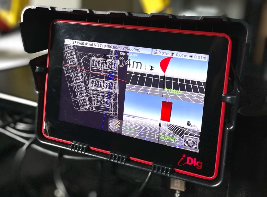 Operator using 3D machine control display in excavator cab